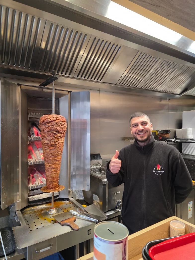 Le chef du Petit Chef devant la broche de kebab cuite au feu de bois